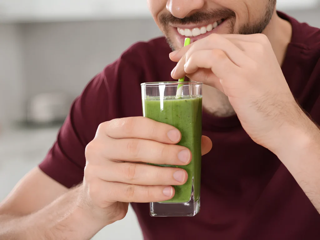 Image of a person satisfied drinking a Dunn pea microgreens smoothie.