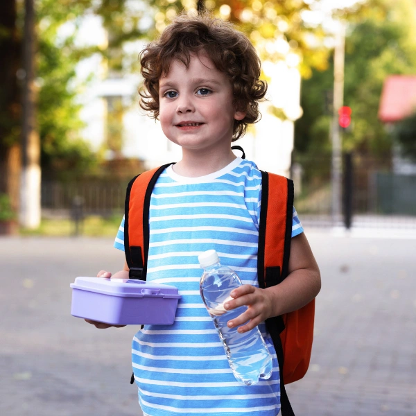 Image of a small child with a lunchbox.