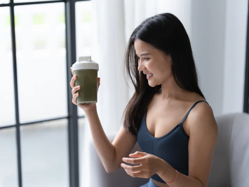 Image showing a person drinking a greens powder smoothie.