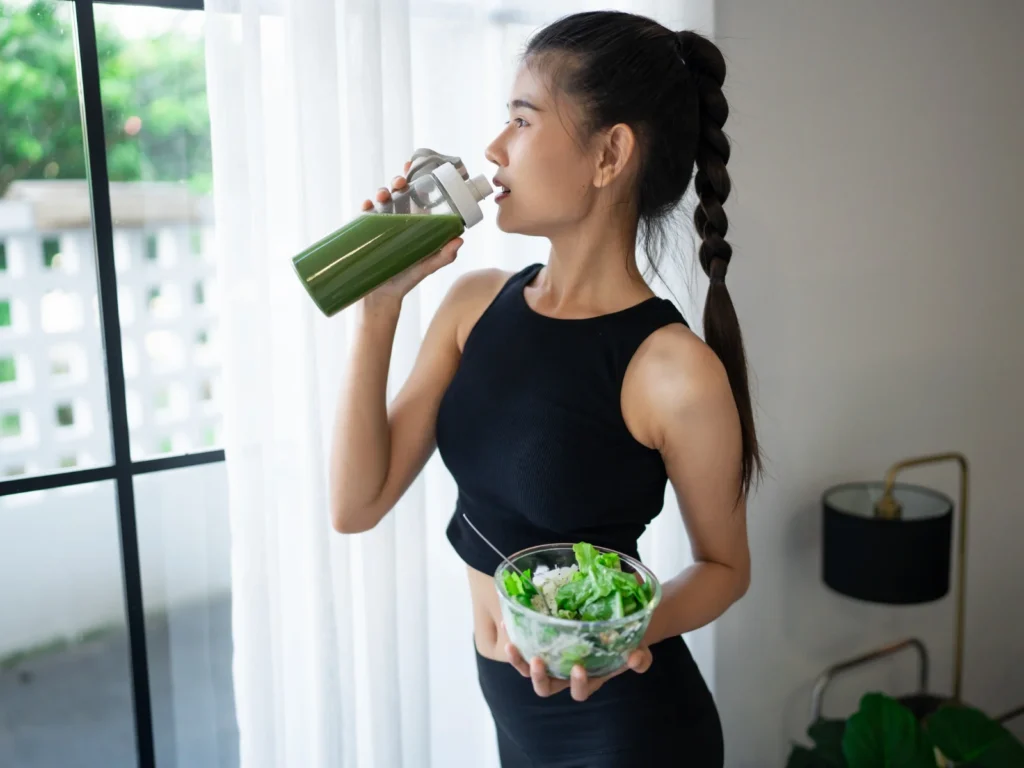 Image showing a person drinking a powedered greens drink post-workout.