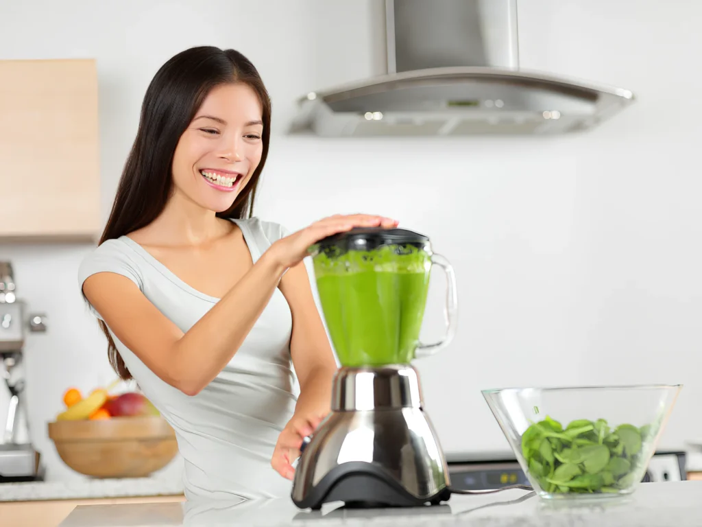 Image of parent blending greens powder smoothie with fresh fruit ingredients.