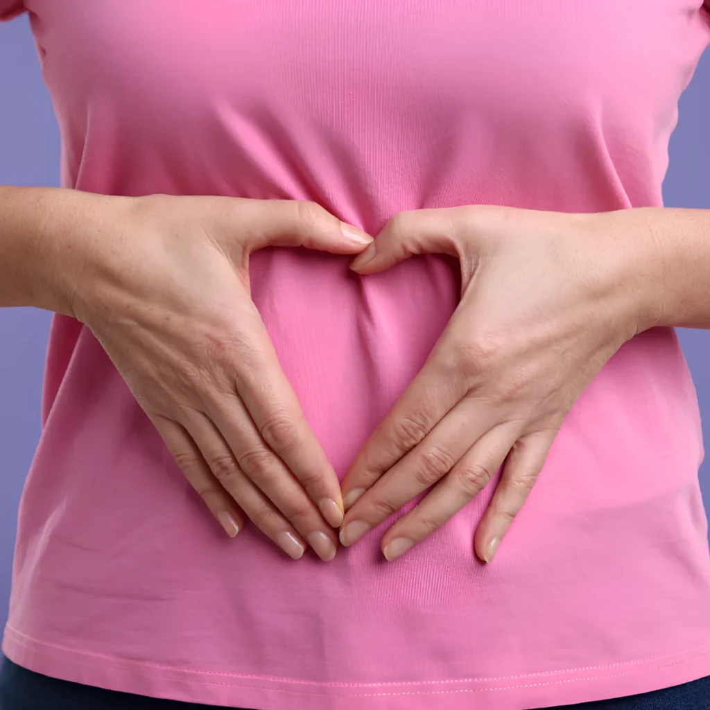 Image representing good gut health with a person making a heart on her stomach.